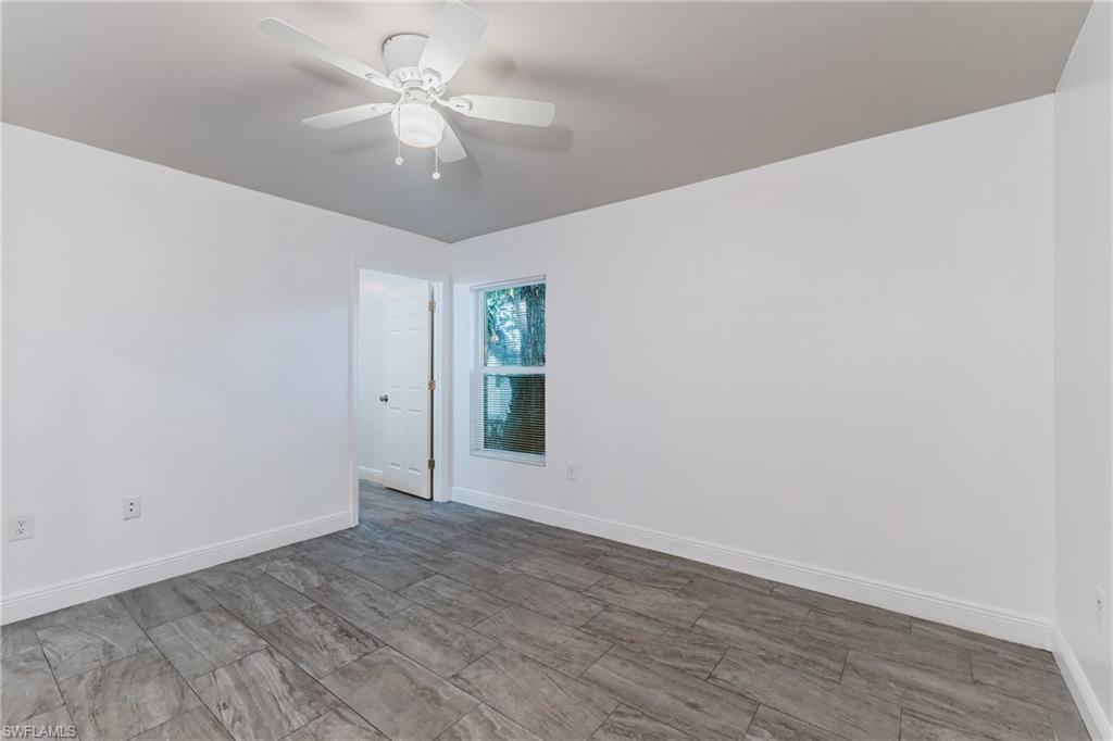 Empty room with ceiling fan and wood tiled floors