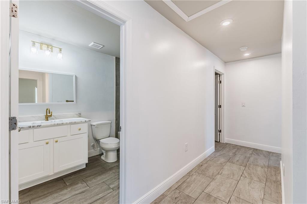 Bathroom with vanity, recessed lighting, and wood tiled floors
