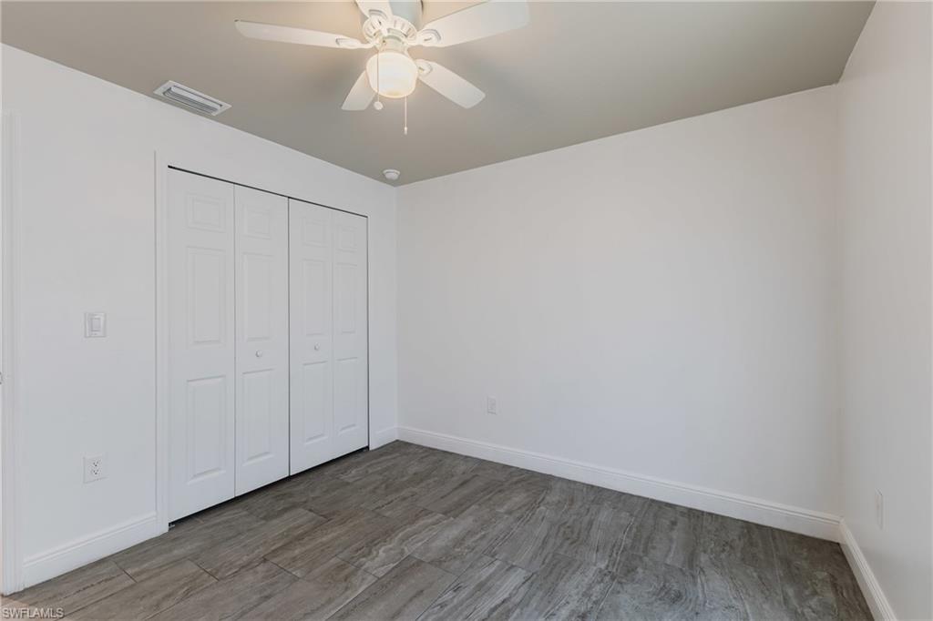 Unfurnished bedroom with wood finished floors, a closet, and ceiling fan