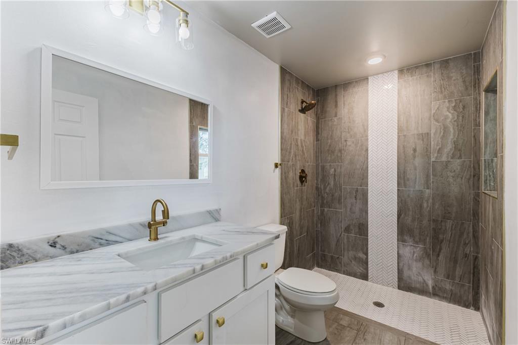 Full bath with vanity and tiled shower