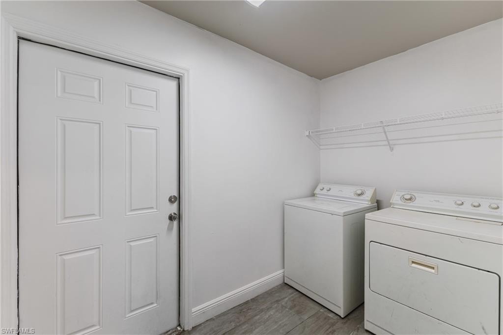 Laundry room with light wood-style floors and independent washer and dryer