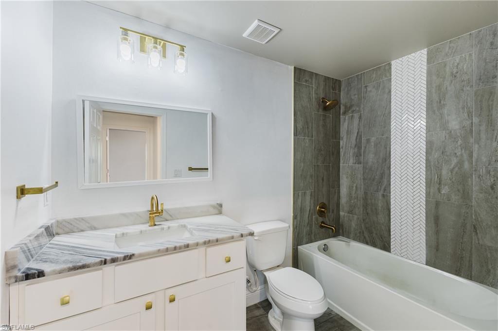 Bathroom featuring shower / bathtub combination with curtain and vanity