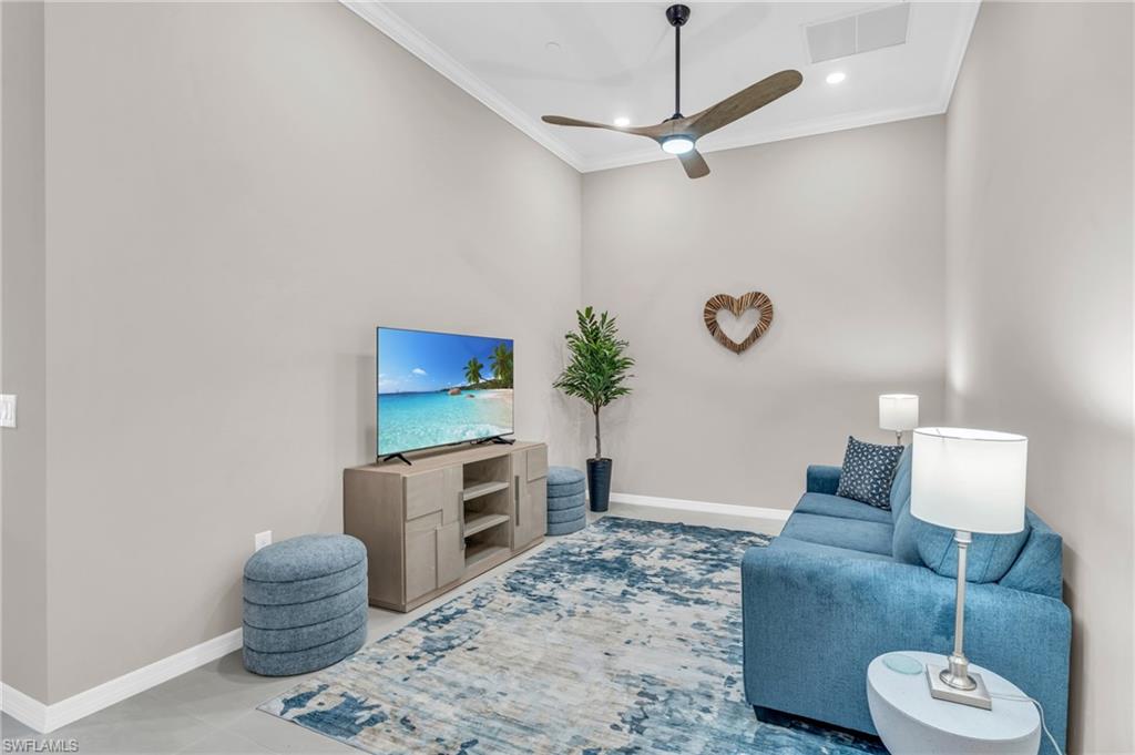 Living room featuring ceiling fan and crown molding