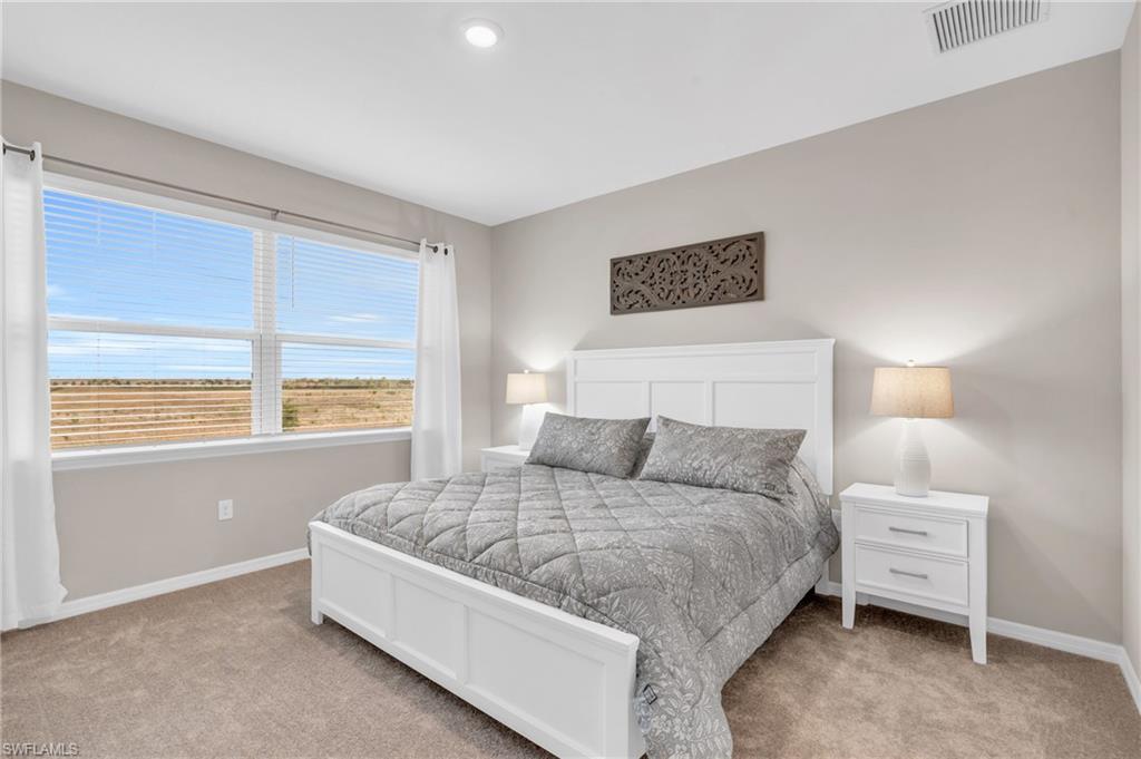 Bedroom featuring light colored carpet