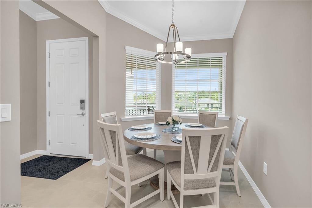 Tiled dining room with a notable chandelier and ornamental molding