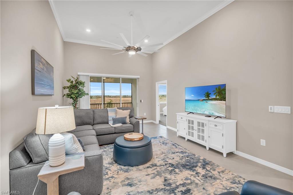 Living room with ceiling fan and ornamental molding