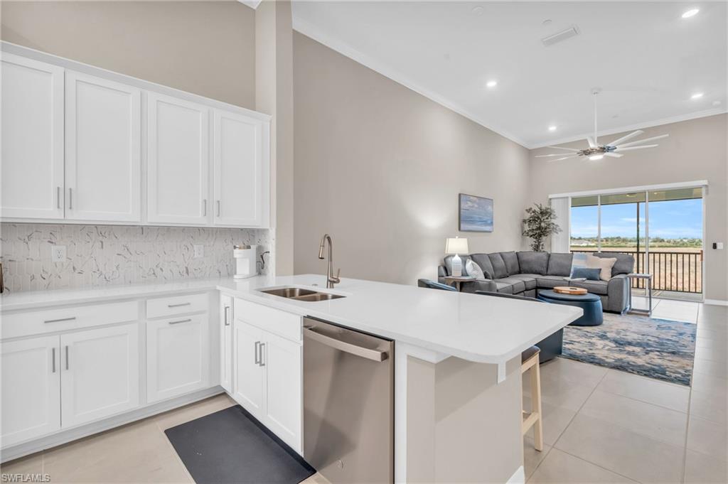Kitchen with sink, white cabinets, stainless steel dishwasher, and kitchen peninsula