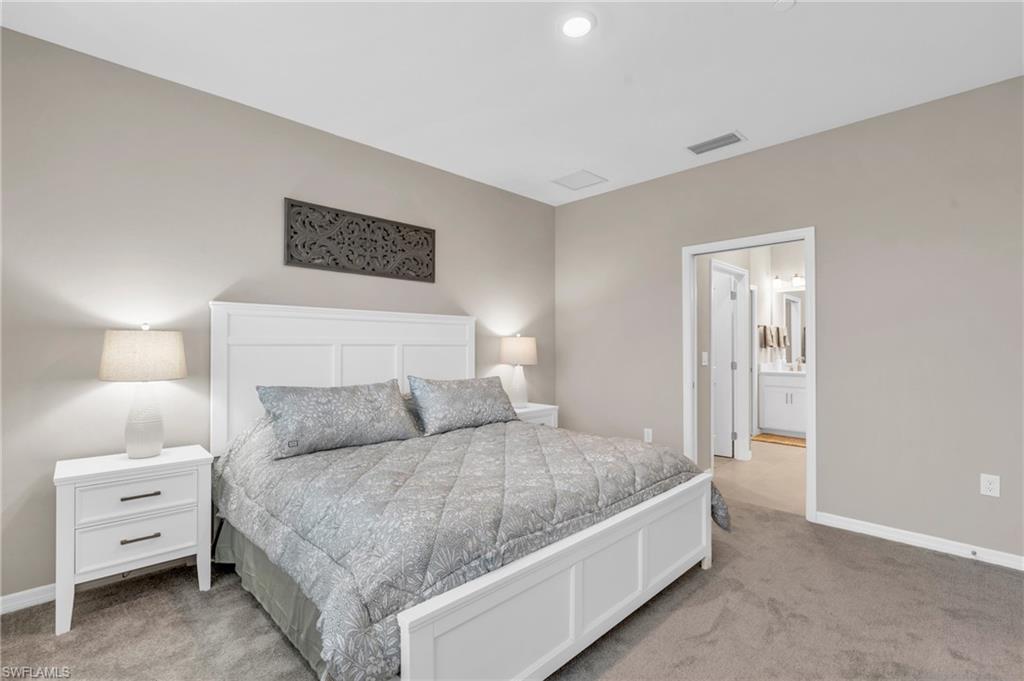 Bedroom with light colored carpet and ensuite bath