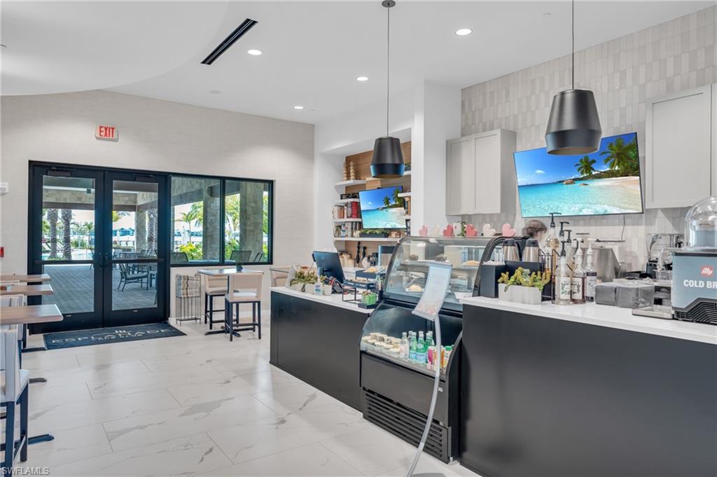 Kitchen featuring french doors, decorative backsplash, white cabinetry, and pendant lighting