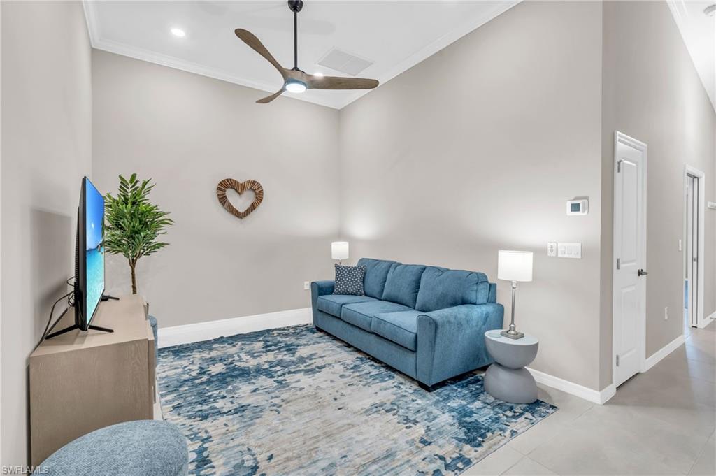 Living room featuring ceiling fan and ornamental molding