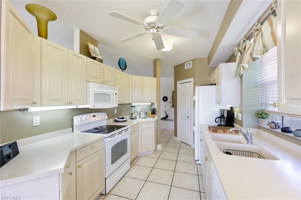 Kitchen featuring white appliances, light countertops, a ceiling fan, and light tile patterned floors