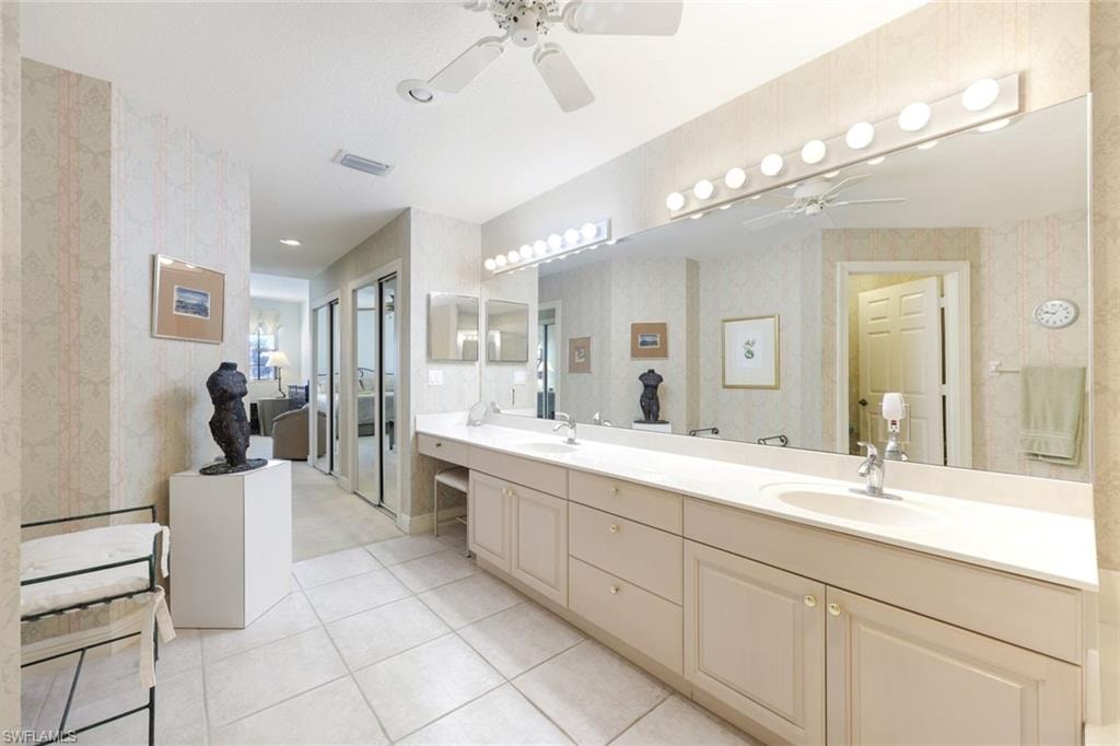 Full bathroom with double vanity, a ceiling fan, wallpapered walls, and light tile patterned flooring