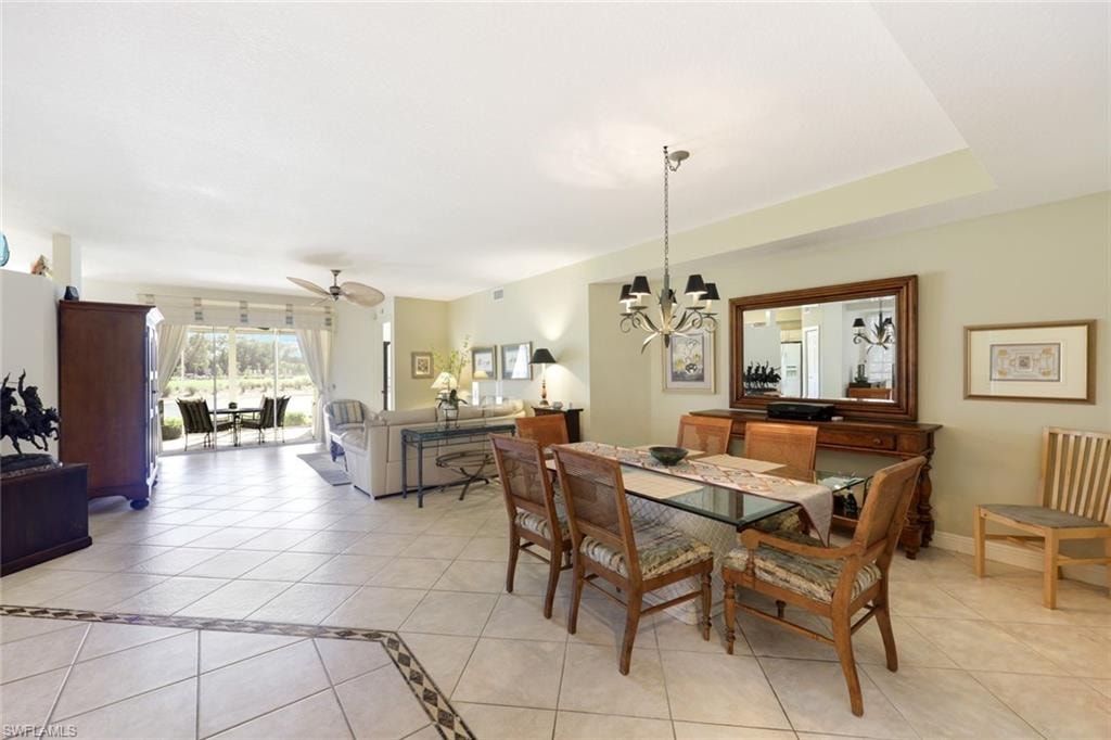 Dining room featuring light tile patterned floors, a ceiling fan, and a chandelier