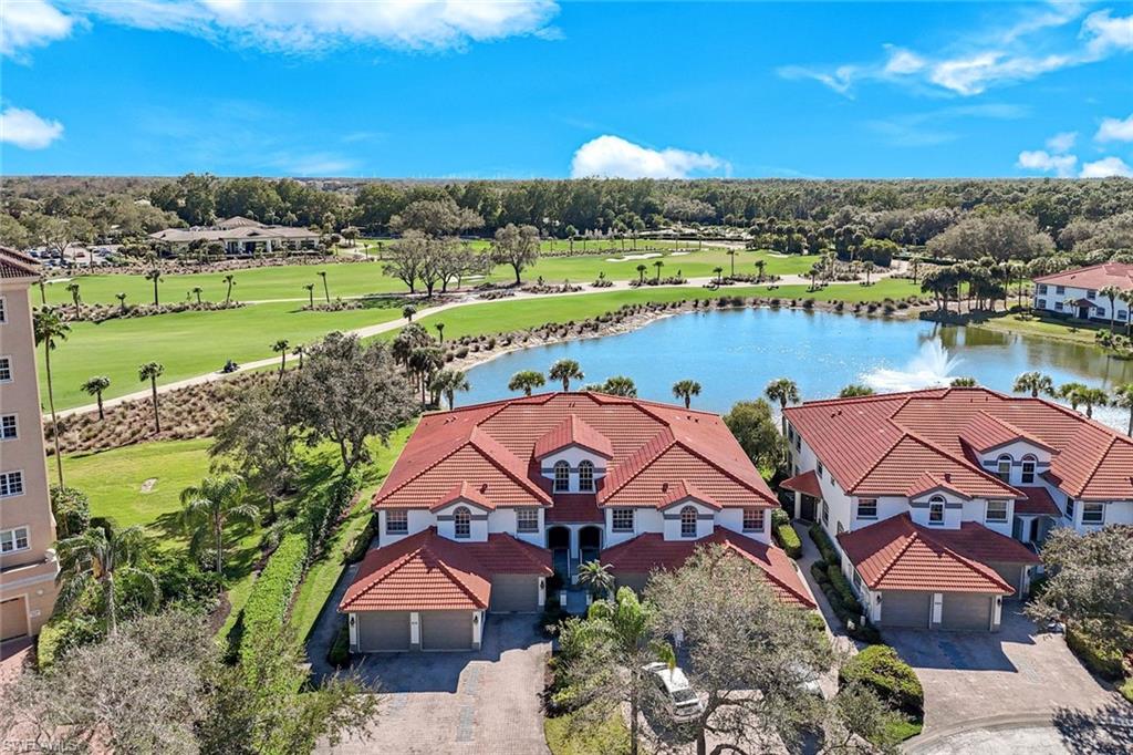 Aerial perspective of suburban area featuring a nearby body of water and a golf course