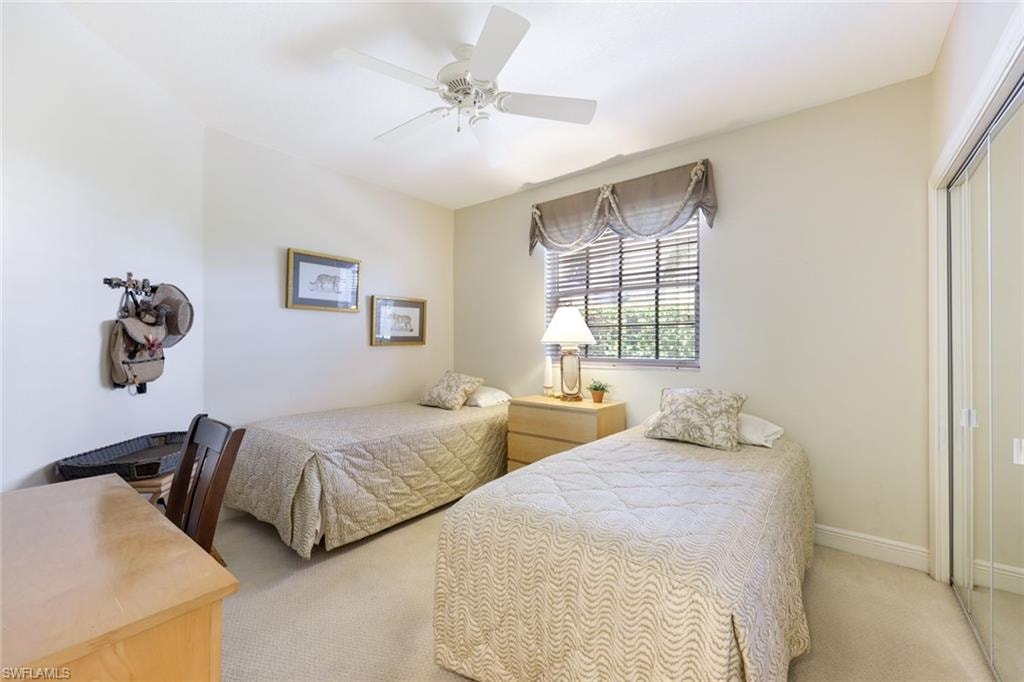 Carpeted bedroom with a ceiling fan and a closet