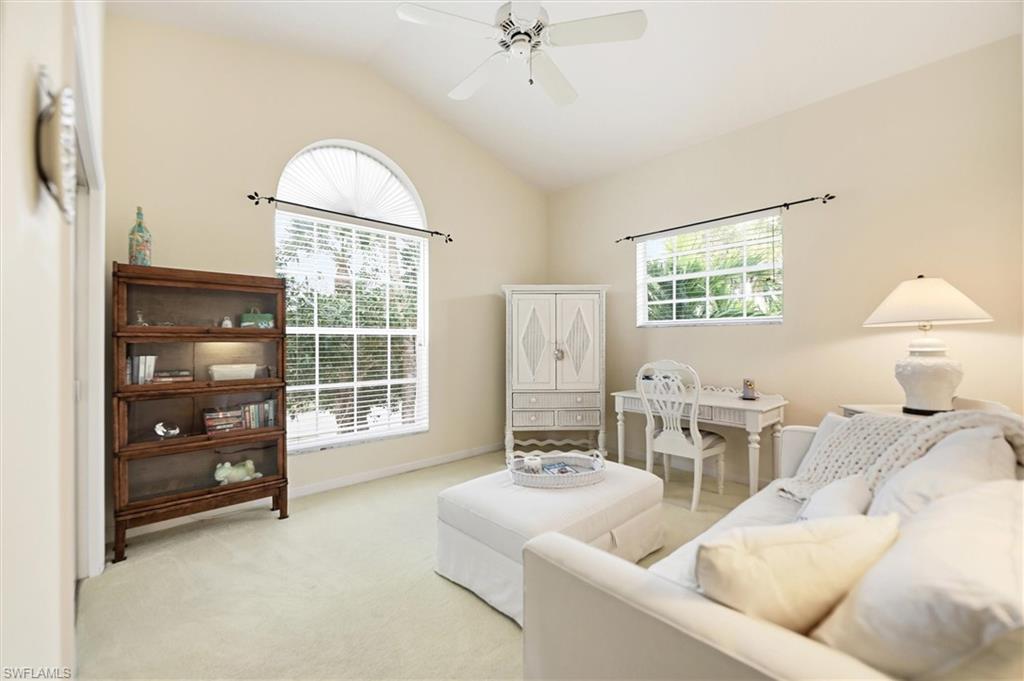 Living room with lofted ceiling, carpet floors, and ceiling fan