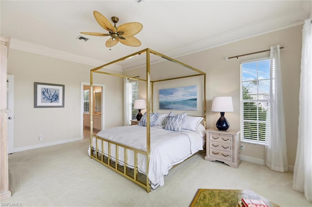 Bedroom with light carpet, a ceiling fan, ornamental molding, and ensuite bathroom