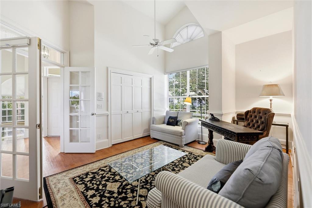 Living room featuring ceiling fan, wood finished floors, and vaulted ceiling