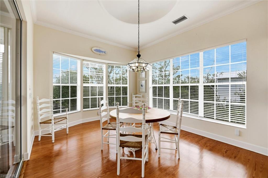 Dining area featuring crown molding, a chandelier, and light wood finished floors