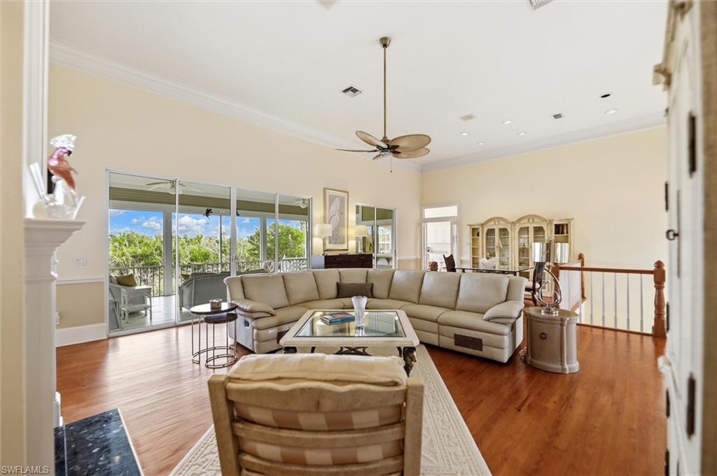 Living area with crown molding, wood finished floors, and a ceiling fan