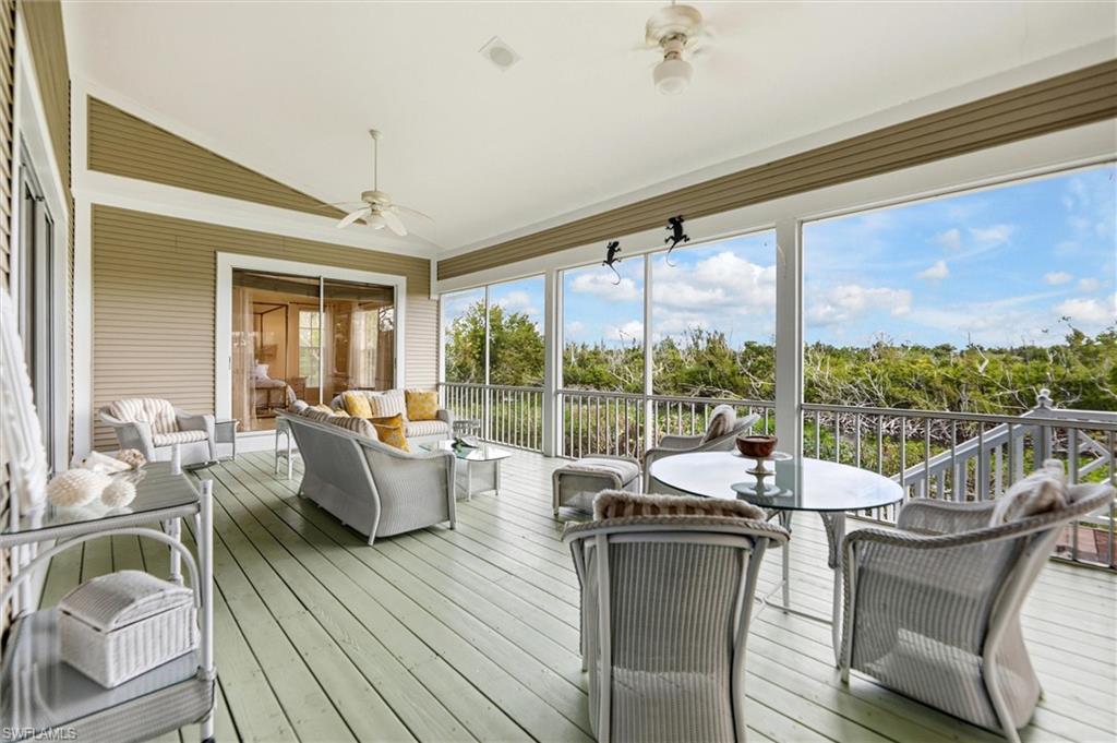 Sunroom with a ceiling fan, lofted ceiling, an outdoor living / dining area, and a wooden deck