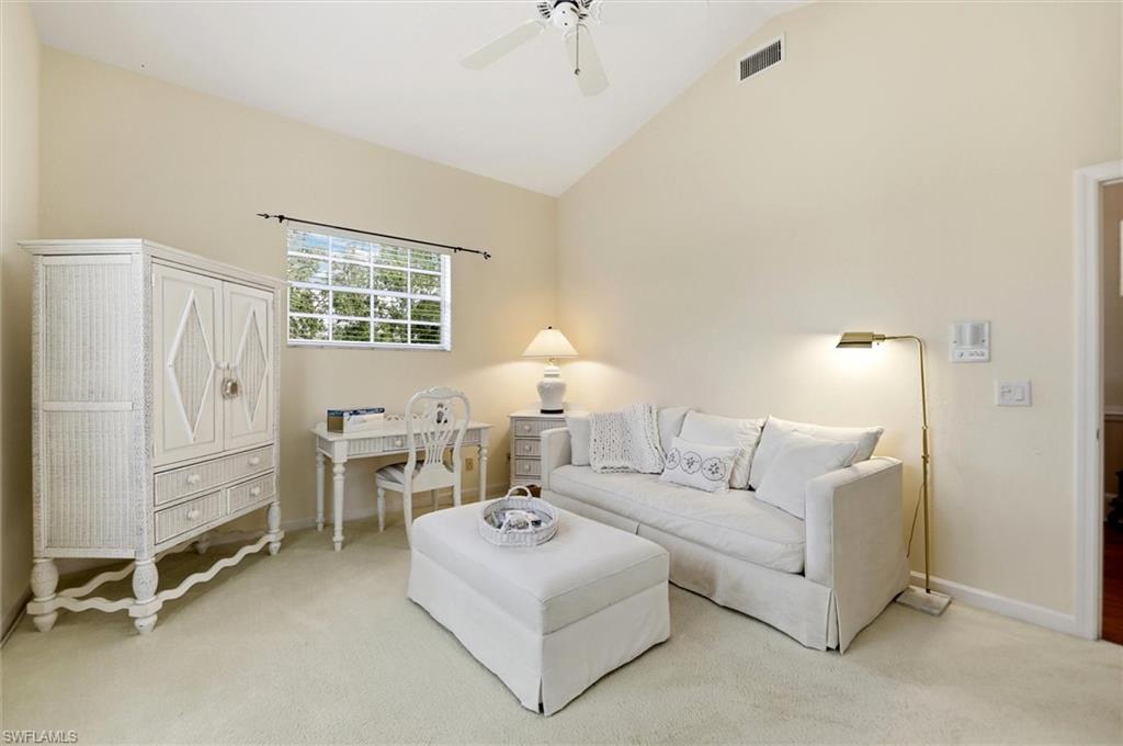 Living room with carpet flooring, vaulted ceiling, and ceiling fan