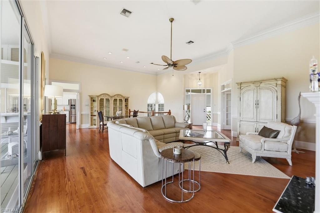Living room featuring crown molding, wood finished floors, ceiling fan, and recessed lighting