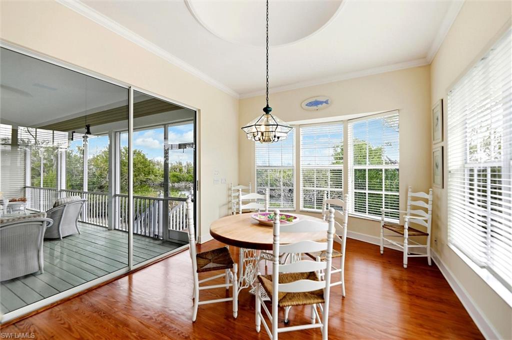 Dining area featuring ornamental molding, wood finished floors, and suspended lighting