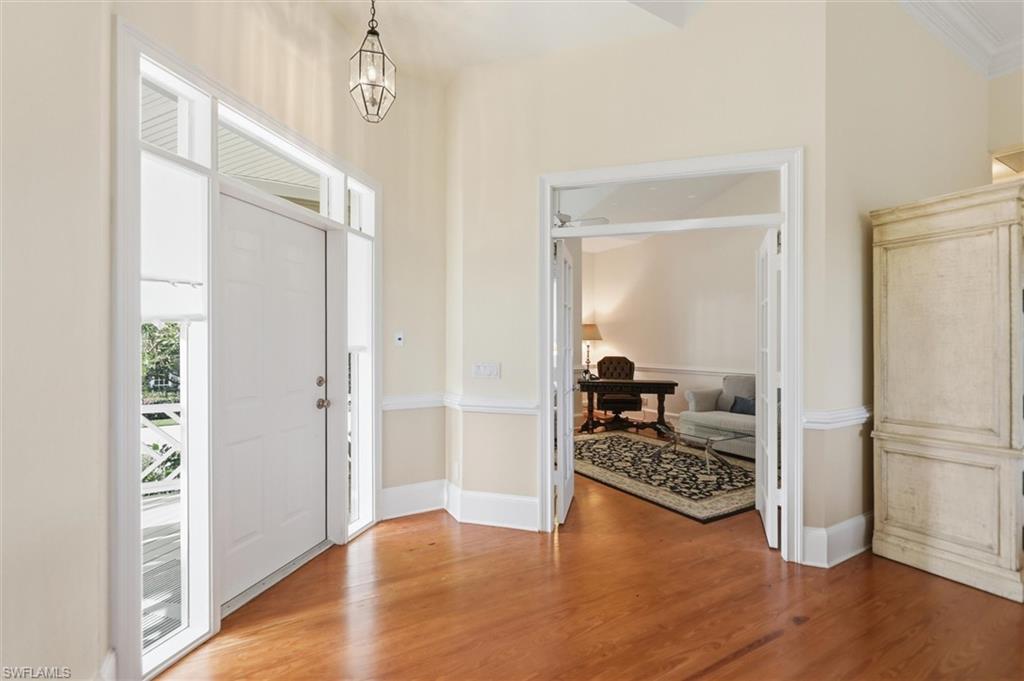 Foyer with wood finished floors and hanging lights
