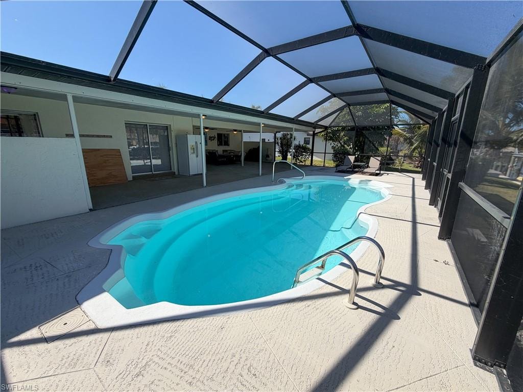 Swimming pool with a lanai, a patio area, and a sunroom
