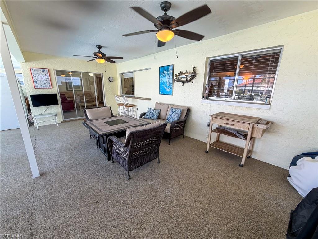 View of patio with an outdoor lounge area and a ceiling fan