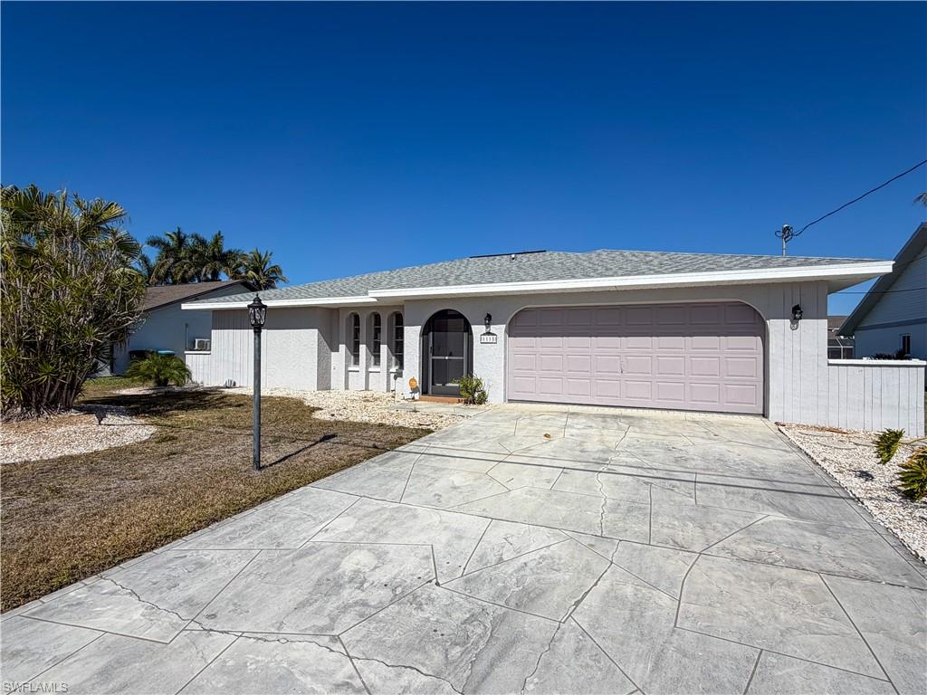 Ranch-style home featuring concrete driveway and a garage