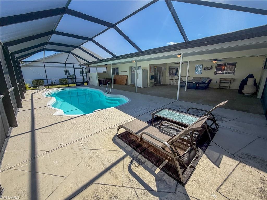 Swimming pool with a patio area, a sunroom, and glass enclosure