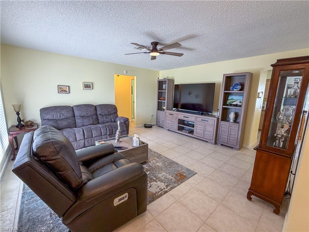 Living area with a textured ceiling and a ceiling fan