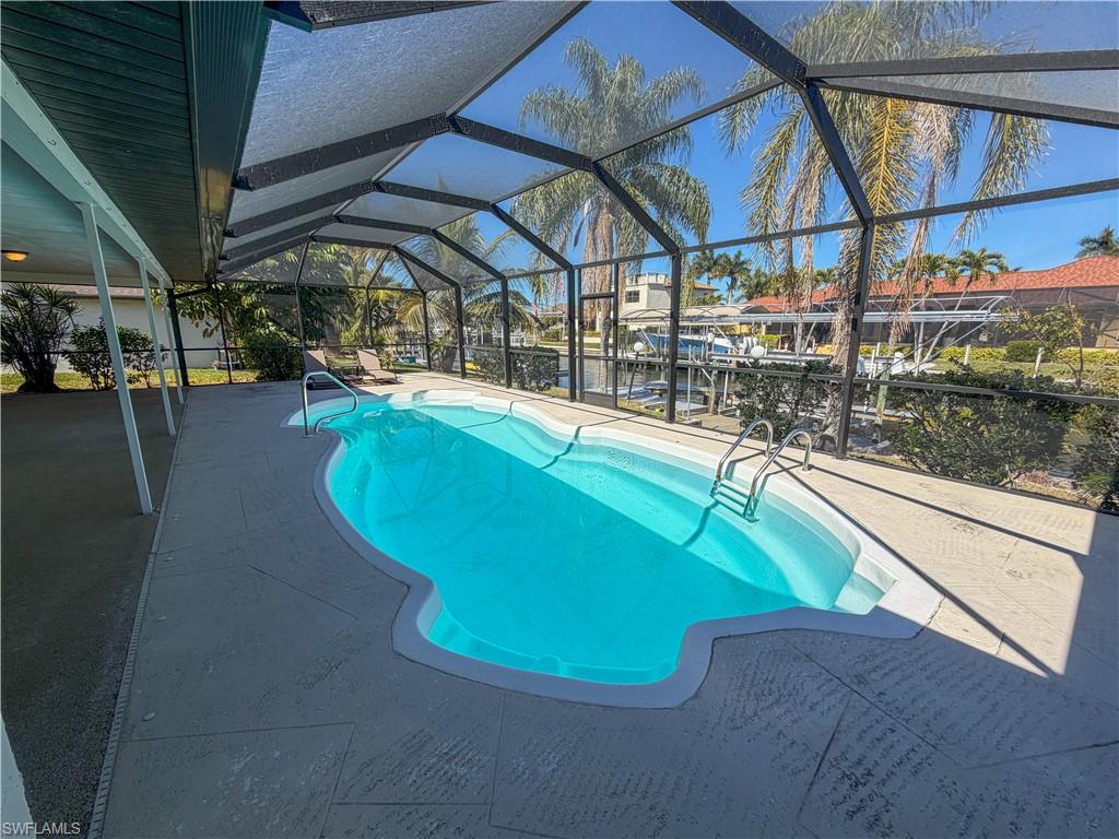 Outdoor pool with a lanai, a patio, and a sunroom