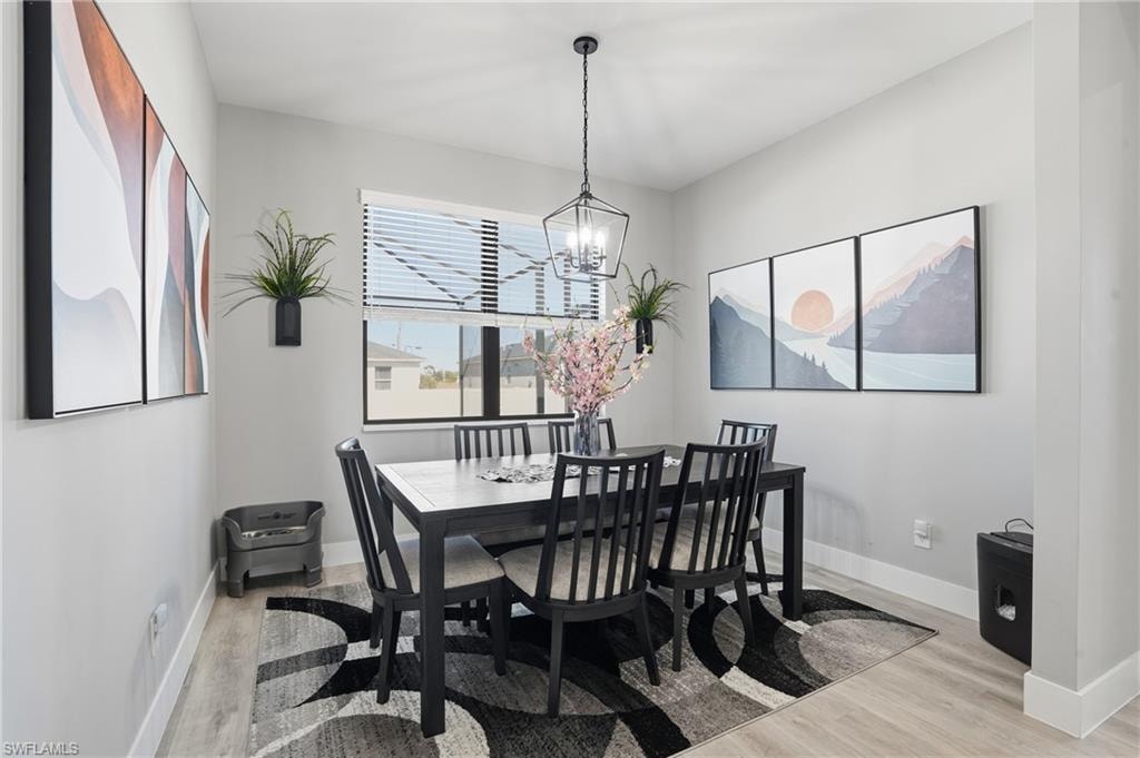 Dining room with light wood finished floors and suspended lighting