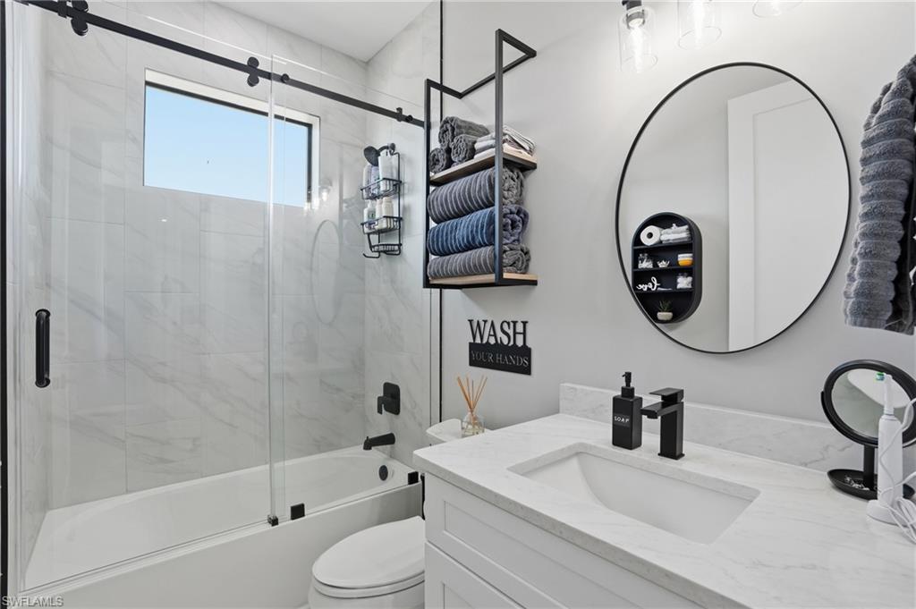 Bathroom featuring vanity and combined bath / shower with glass door