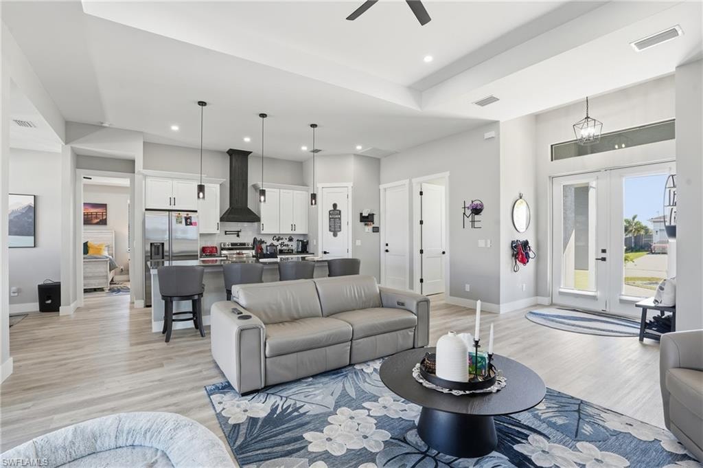 Living area featuring light wood-style flooring, french doors, ceiling fan, and recessed lighting