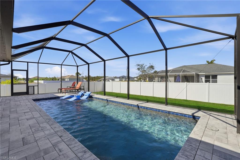 View of pool with a sunroom, a fenced backyard, and a lanai