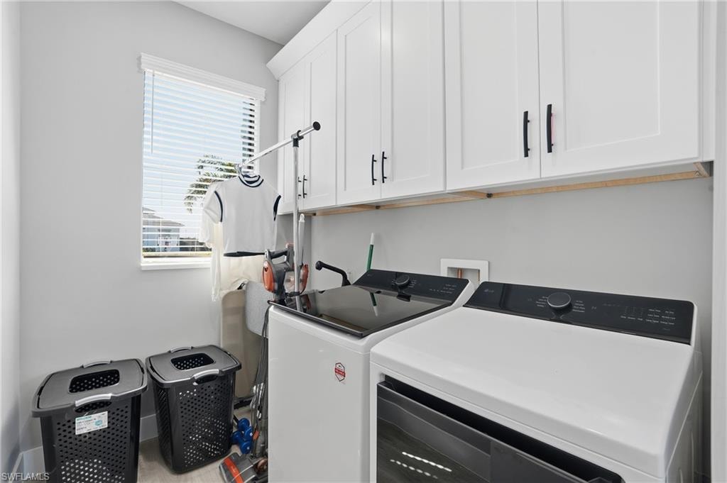 Laundry area featuring cabinet space and washer and clothes dryer