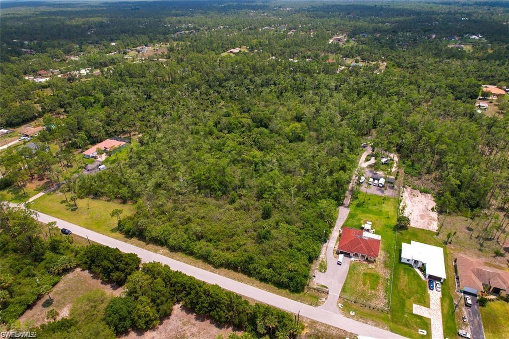 Aerial view of property and surrounding area featuring a heavily wooded area