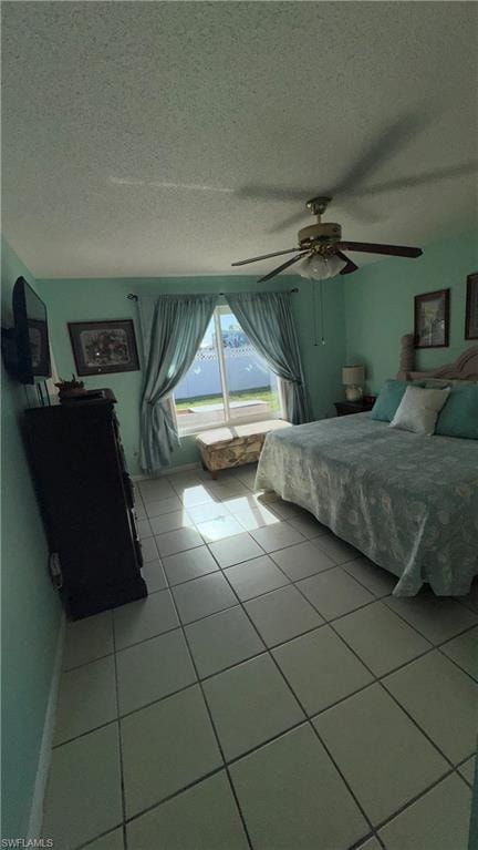 Tiled bedroom with a textured ceiling and ceiling fan