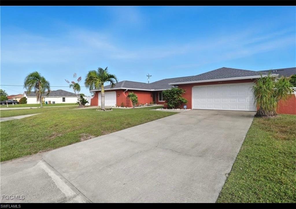 Ranch-style house featuring a front yard, an attached garage, concrete driveway, and roof with shingles