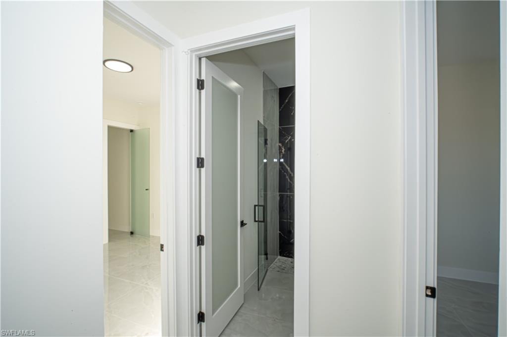 Corridor with baseboards and light marble finish floors