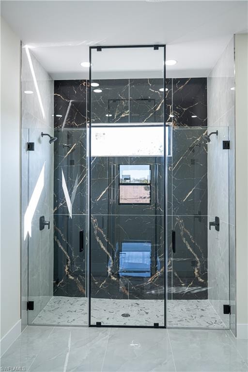 Full bath with a marble finish shower