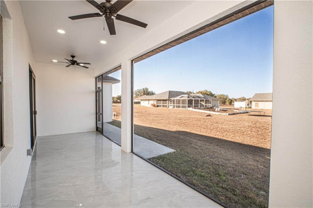 View of patio with a ceiling fan and a sunroom