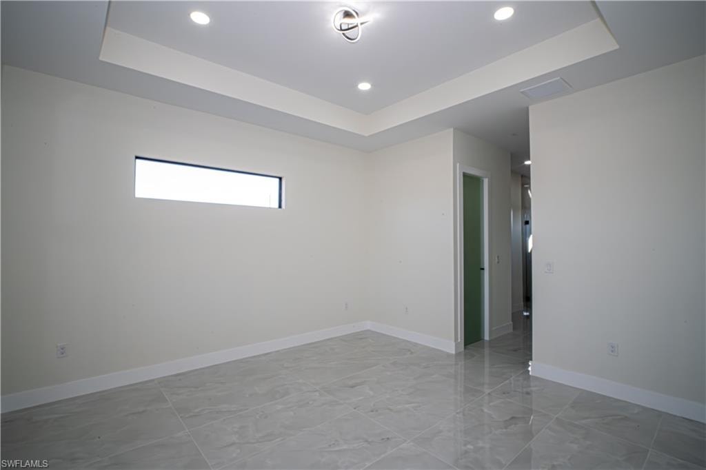 Spare room with a tray ceiling and recessed lighting