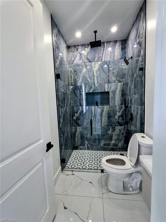 Full bathroom featuring light marble finish flooring, a marble finish shower, vanity, and recessed lighting