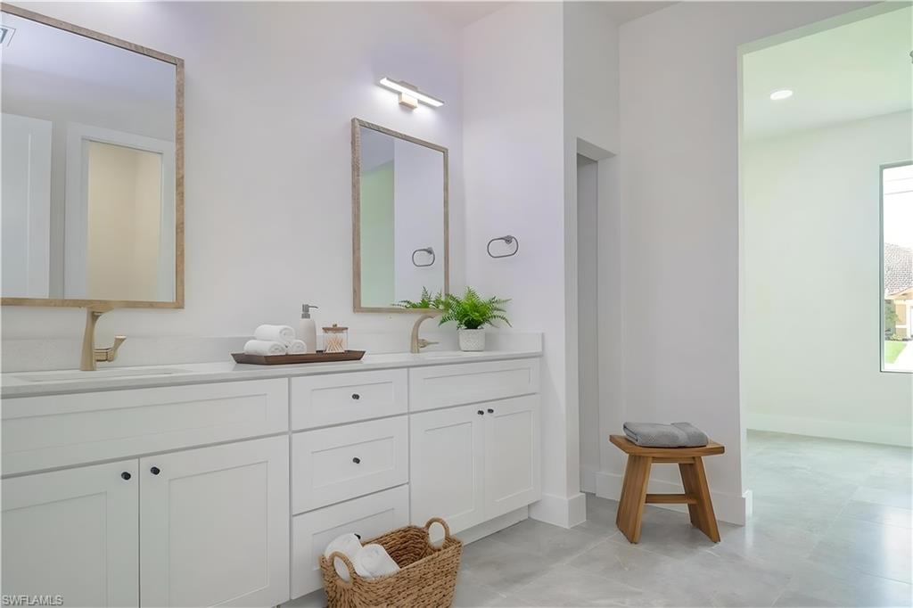 Bathroom featuring double vanity and baseboards