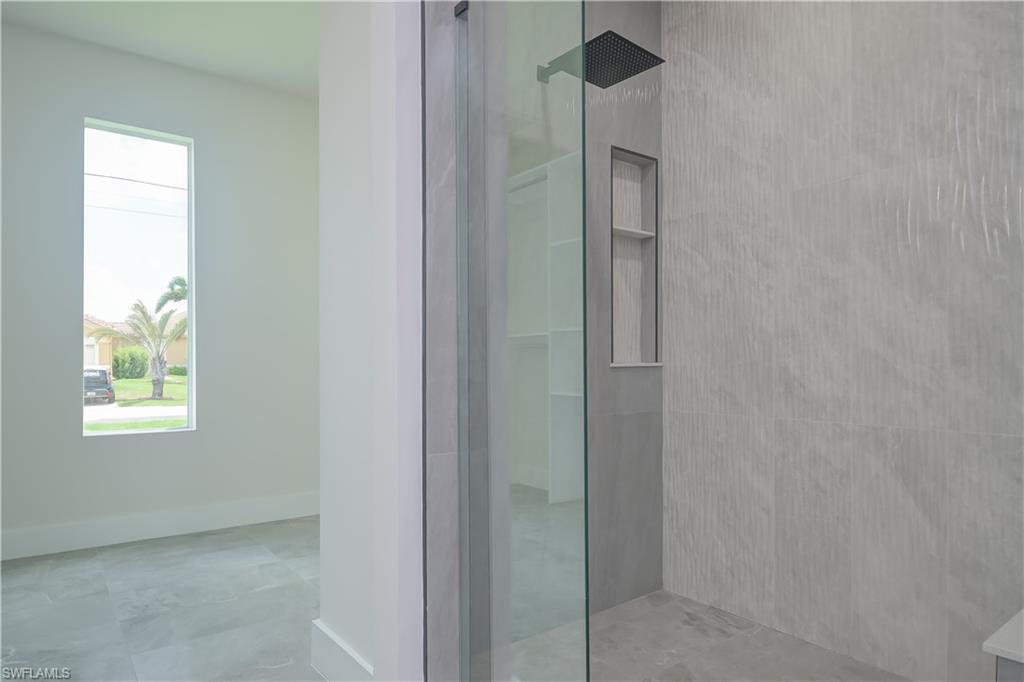 Bathroom featuring walk in shower and baseboards